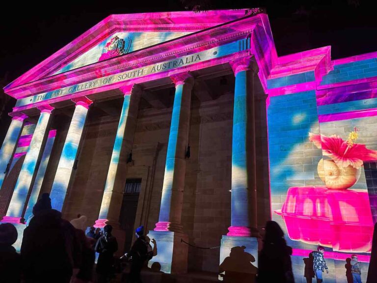 The Art Gallery of South Australia illuminated at night with vibrant light projections, showcasing the cultural vibrancy of living in Adelaide.
