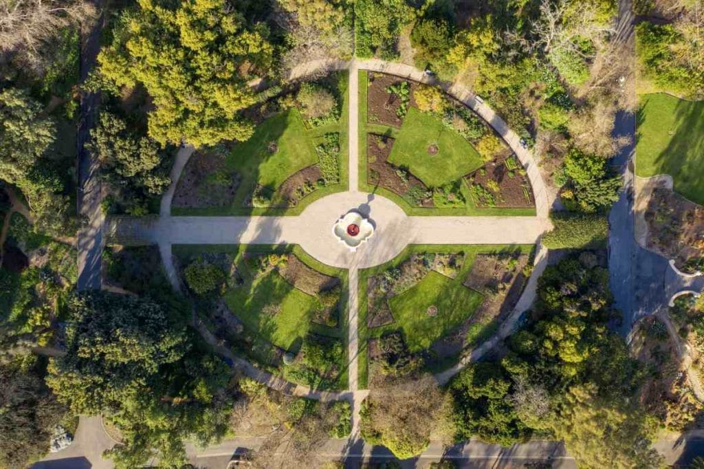 Aerial view of the Adelaide Botanic Garden showing a symmetrical layout with lush greenery, garden beds, and a central fountain. This iconic spot is one of the most peaceful and well-preserved historical sites in Adelaide, reflecting the city's colonial garden design from the 19th century.