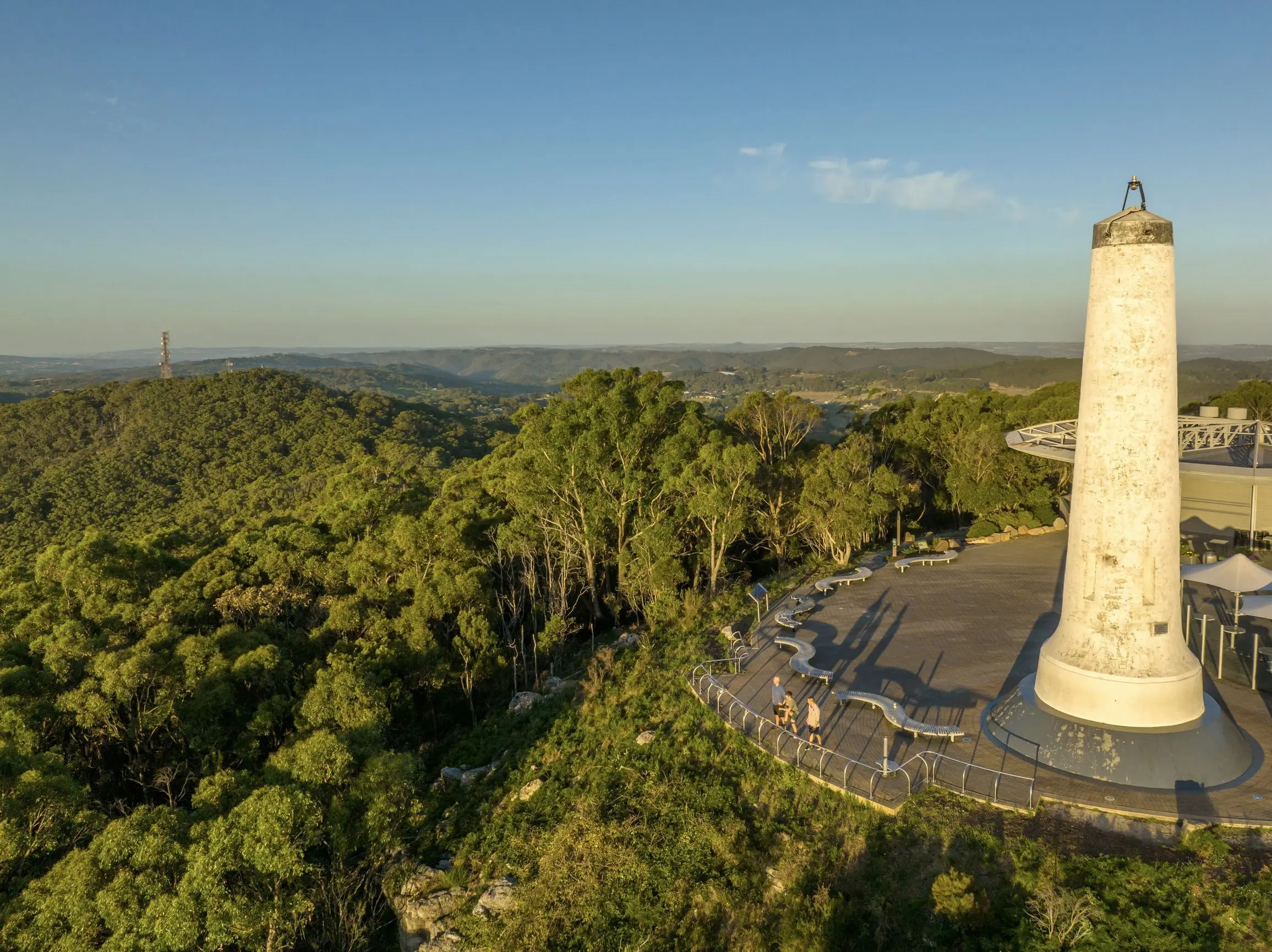 An aerial view of the Mount Lofty Summit lookout shows the historic white obelisk surrounded by native bushland with sweeping views across the Adelaide Hills. Visiting this scenic viewpoint is one of the top places to visit in Adelaide for panoramic landscapes and peaceful nature escapes.
